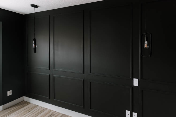 Moody black moulding wall DIY with hanging pendant lights and light wood floors